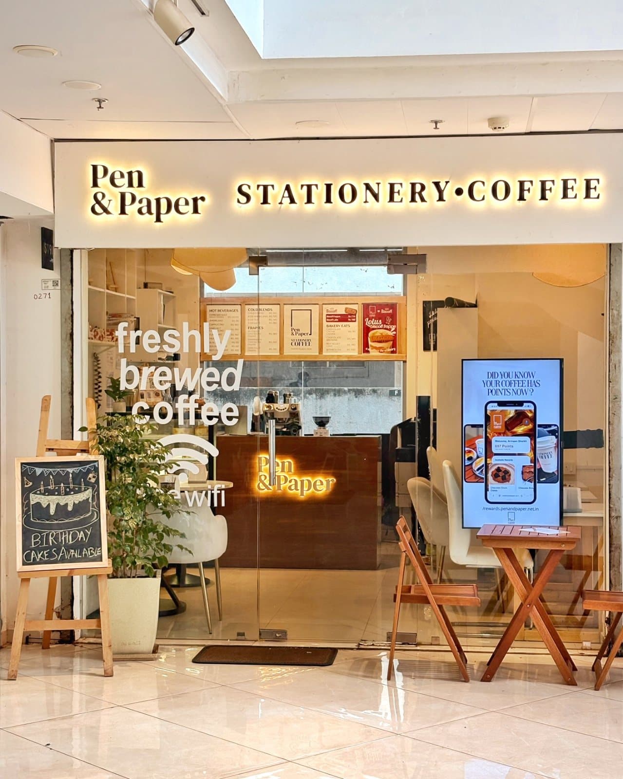 The Stationery Coffee storefront in Patto Plaza, its lit sign reading Pen & Paper · Stationery · Coffee.